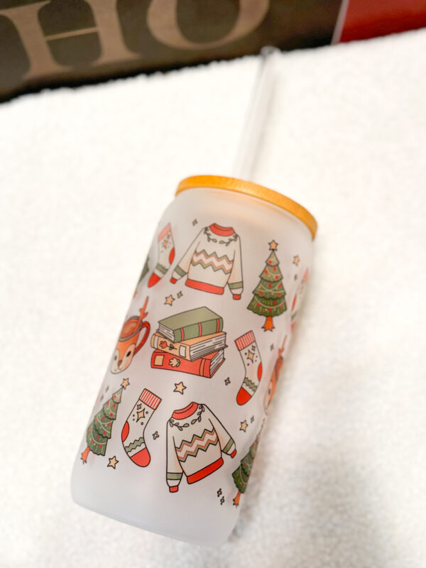 Sip your favorite holiday beverages in style with this 16oz frosted glass can featuring a cozy and festive design! Adorned with a sweater, Christmas tree, books, stockings, and reindeer, this cup is perfect for anyone who loves the warm and fuzzy vibes of the holiday season.