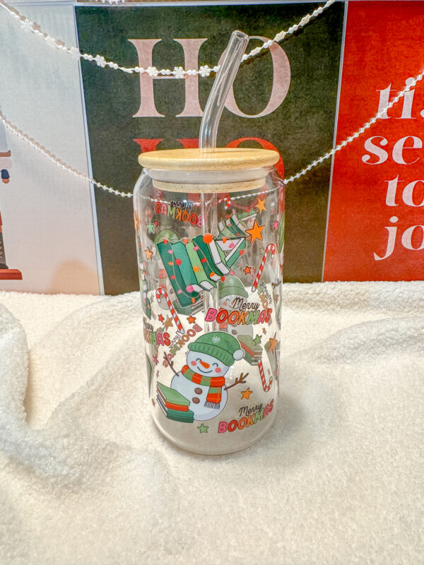 This Merry Bookmas 16oz glass can is the ultimate bookish gift for the holiday season! Designed for book lovers and Christmas enthusiasts alike, this double-sided UV DTF tumbler features a whimsical Christmas tree made of books, a cheerful snowman, candy canes, stars, and festive lights—all in a bright, colorful design that celebrates the coziness of the season.