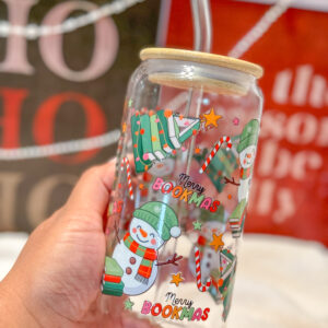 This Merry Bookmas 16oz glass can is the ultimate bookish gift for the holiday season! Designed for book lovers and Christmas enthusiasts alike, this double-sided UV DTF tumbler features a whimsical Christmas tree made of books, a cheerful snowman, candy canes, stars, and festive lights—all in a bright, colorful design that celebrates the coziness of the season.