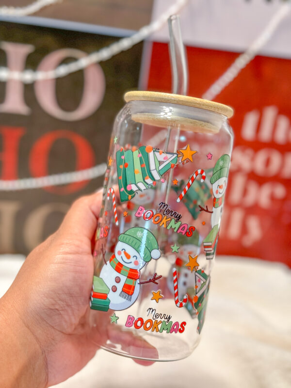 This Merry Bookmas 16oz glass can is the ultimate bookish gift for the holiday season! Designed for book lovers and Christmas enthusiasts alike, this double-sided UV DTF tumbler features a whimsical Christmas tree made of books, a cheerful snowman, candy canes, stars, and festive lights—all in a bright, colorful design that celebrates the coziness of the season.