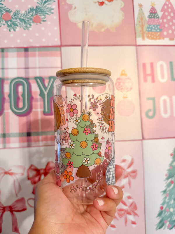 Add a touch of retro flair to your holiday drinkware collection with this 16oz Groovy Christmas glass can! Featuring a double-sided UV DTF design, this unique tumbler brings together a festive disco ball, a Christmas tree adorned with smiley-face string lights, and the playful words "Ho Ho Ho" for a cheerful vibe.